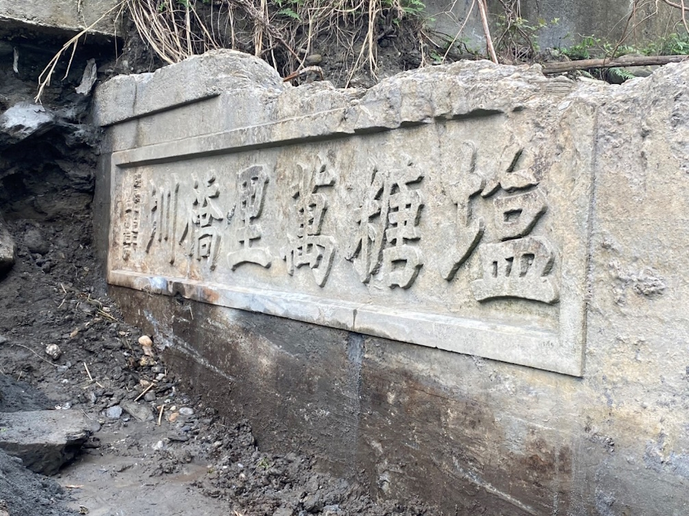 圖1：康芮颱風過後，河床刷深，百年老圳「塩糖萬里橋圳」石碑撥泥見日